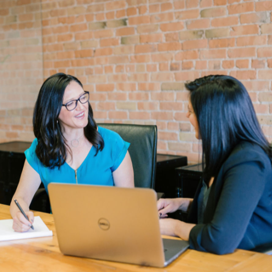 Two professional women having business meeting with laptop in modern office