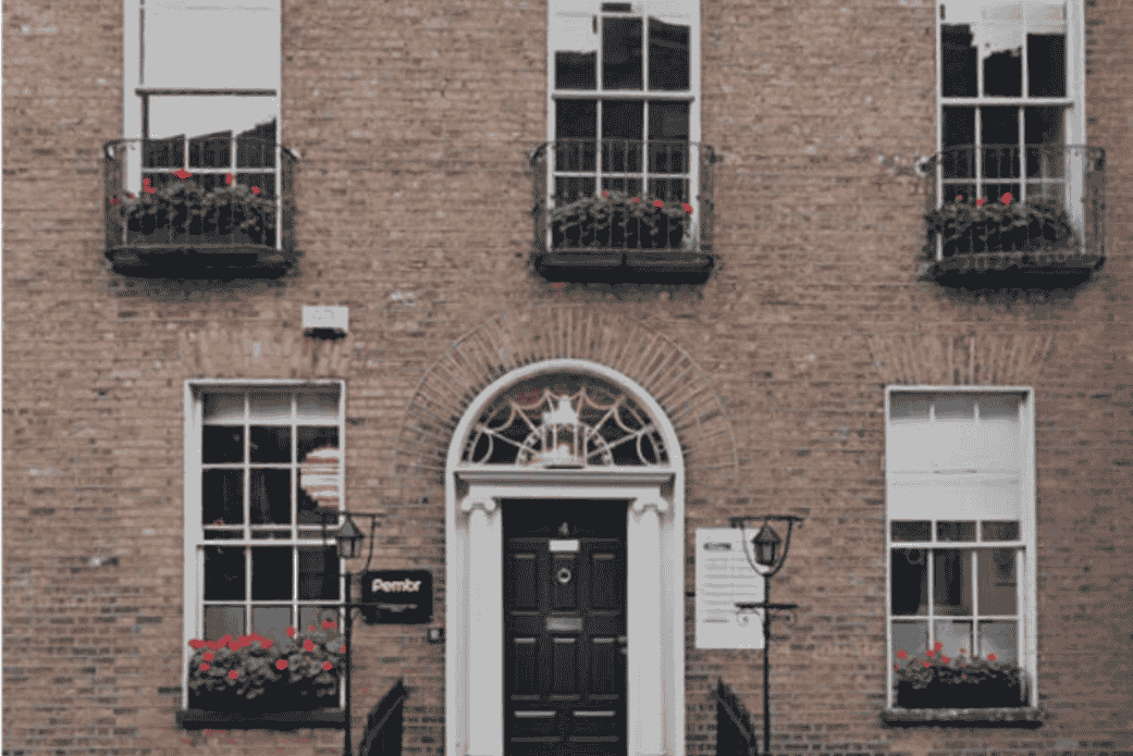 Classic brick building facade with symmetrical windows and arched doorway entrance